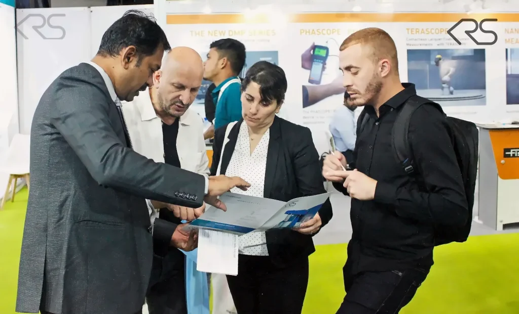 KRS representative discussing machine documentation with visitors at ECS 2025